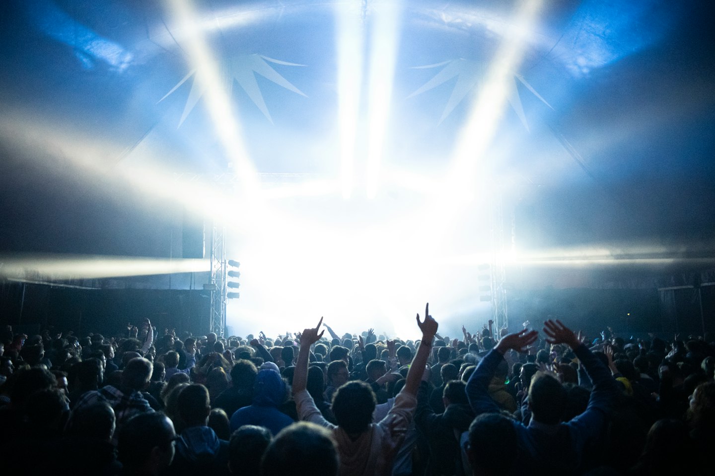 Une foule lève les mains avec enthousiasme lors d'un concert.